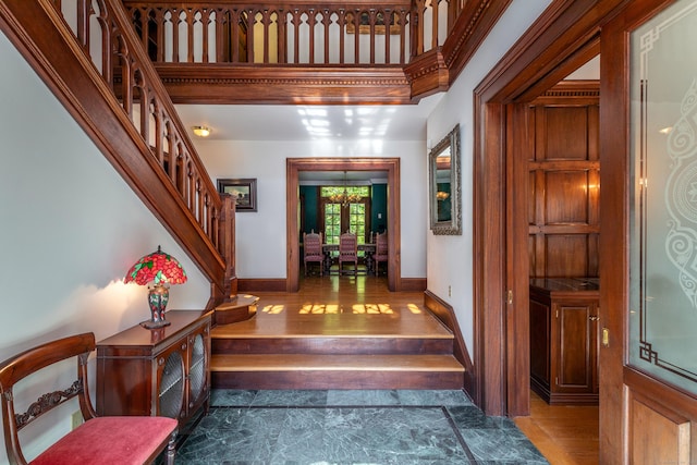 foyer entrance with stairway, baseboards, and wood finished floors