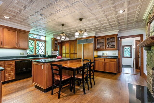 kitchen with a kitchen island, dishwasher, a kitchen breakfast bar, hanging light fixtures, and a notable chandelier