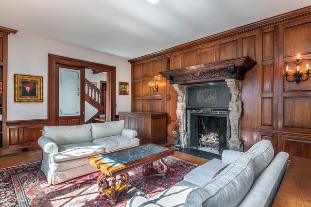 living room with wood-type flooring and a stone fireplace