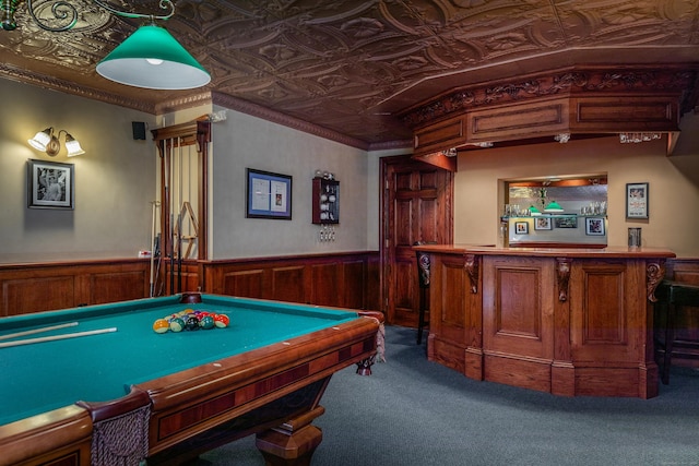 game room featuring a wainscoted wall, carpet flooring, an ornate ceiling, and a bar