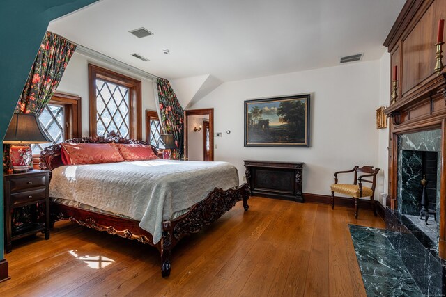 bedroom featuring hardwood / wood-style flooring and a fireplace