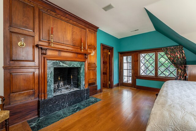 bedroom with a premium fireplace and dark hardwood / wood-style flooring