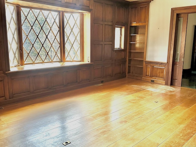 empty room featuring a decorative wall and light wood finished floors