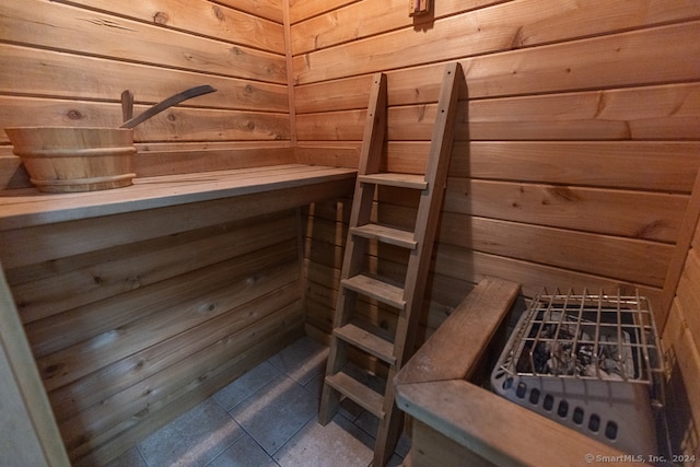 view of sauna with tile patterned floors and wooden walls