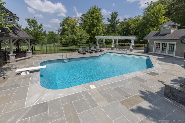 view of pool featuring a gazebo, an outbuilding, a diving board, and a patio