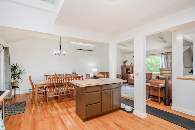 kitchen with decorative light fixtures, light hardwood / wood-style flooring, a chandelier, and a wall mounted air conditioner