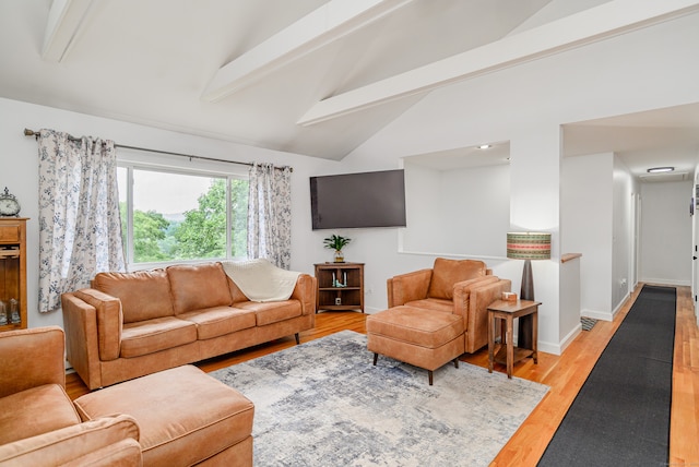 living room featuring lofted ceiling with beams and light hardwood / wood-style floors