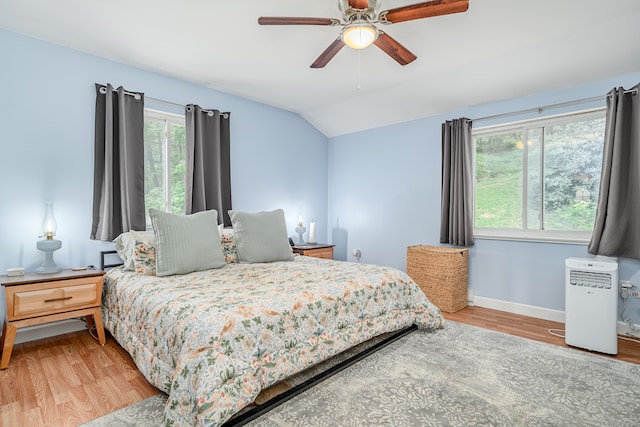 bedroom featuring light hardwood / wood-style floors, multiple windows, and ceiling fan