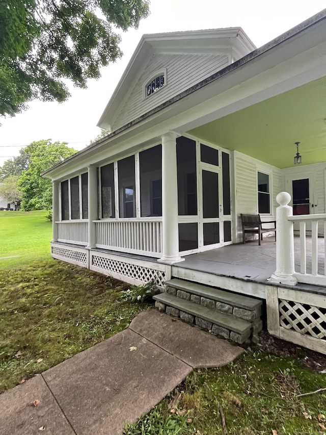 view of property exterior with a lawn and a sunroom