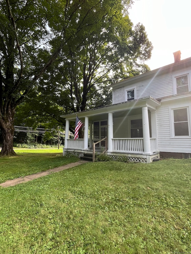 view of front of house featuring covered porch and a front lawn