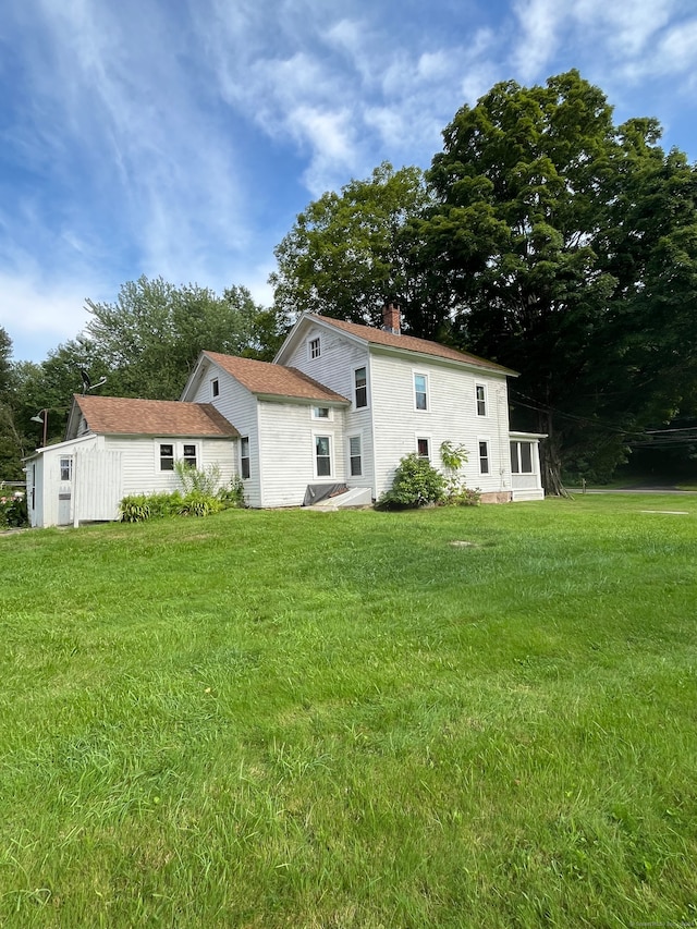 rear view of property featuring a lawn