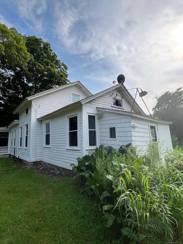 view of side of home with a yard