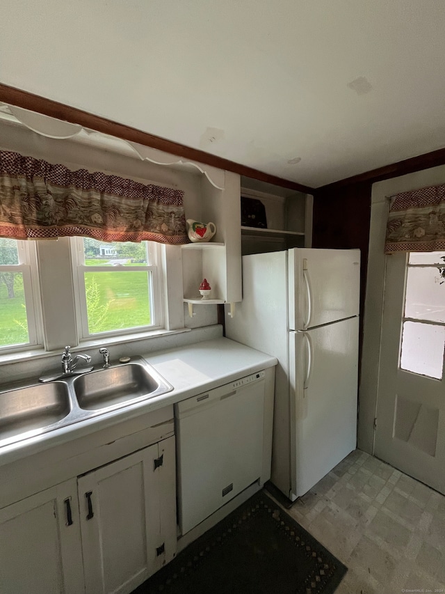 kitchen with white cabinets, sink, and white appliances