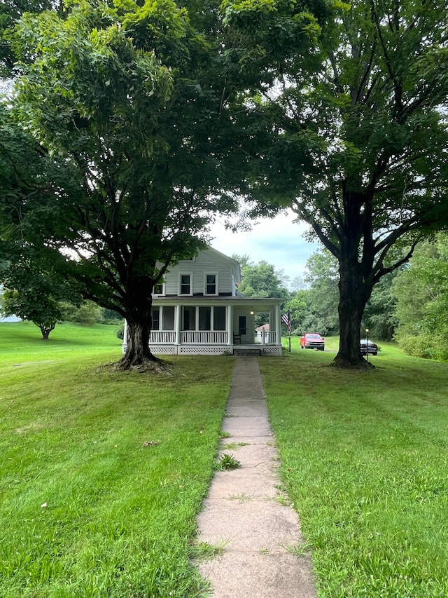 farmhouse featuring a front lawn and a porch