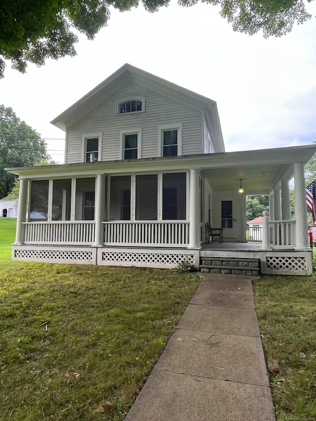 farmhouse-style home featuring a front lawn and covered porch