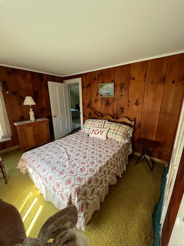 bedroom featuring light carpet and wood walls