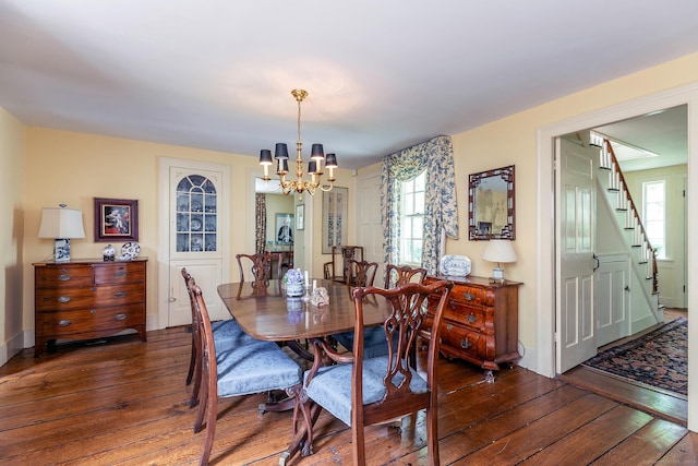 dining space with dark hardwood / wood-style floors and a notable chandelier