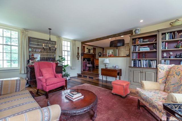 living room featuring an inviting chandelier, a healthy amount of sunlight, and dark wood-type flooring