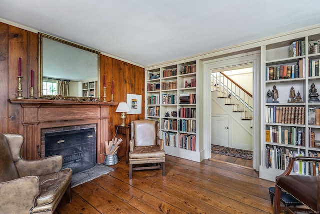 sitting room featuring wood-type flooring and wooden walls