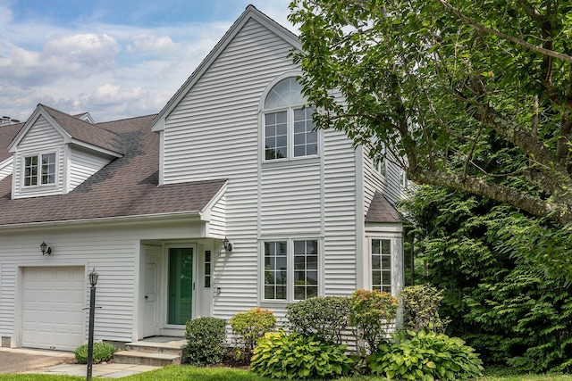 view of front of house featuring a garage and roof with shingles