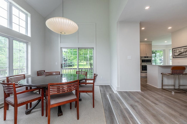 dining space featuring recessed lighting, a healthy amount of sunlight, baseboards, and light wood-style floors