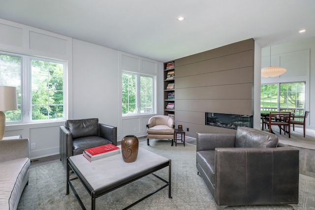 living room featuring built in shelves and a large fireplace