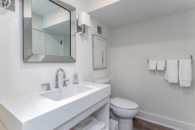 bathroom featuring vanity, toilet, and hardwood / wood-style flooring