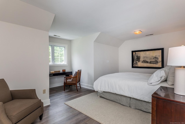 bedroom featuring visible vents, baseboards, and wood finished floors