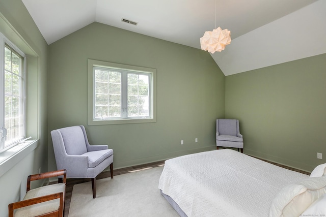 bedroom with vaulted ceiling, multiple windows, baseboards, and visible vents