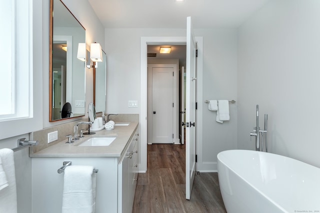 bathroom featuring dual vanity, a bathing tub, and hardwood / wood-style floors