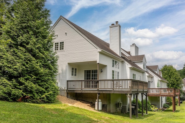 rear view of house featuring central air condition unit, a yard, a chimney, and a wooden deck