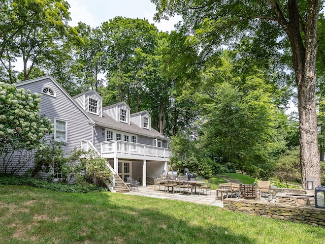 back of house with an outdoor fire pit, a patio, stairs, a deck, and a yard