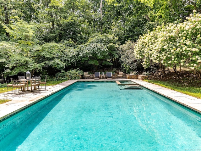 view of swimming pool featuring a pool with connected hot tub and a patio