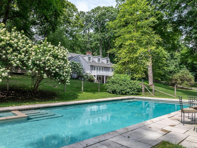 pool with a patio area and a lawn