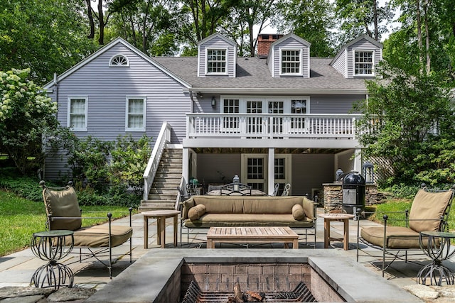 back of house with an outdoor hangout area, roof with shingles, stairway, and a patio area