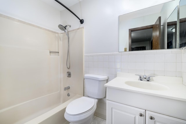 full bathroom with a wainscoted wall, tile walls, shower / bathing tub combination, toilet, and vanity