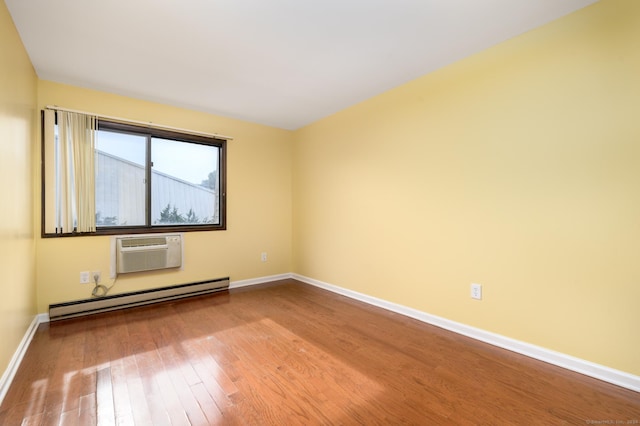 spare room with a baseboard radiator, baseboards, hardwood / wood-style floors, and a wall mounted AC