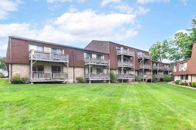 back of property featuring brick siding and a lawn