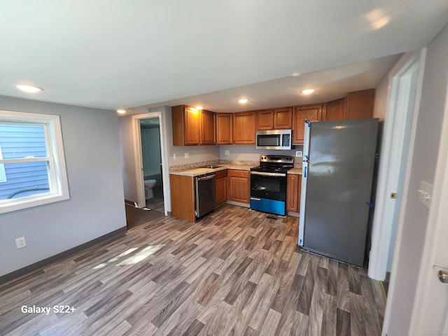 kitchen with appliances with stainless steel finishes and dark hardwood / wood-style floors