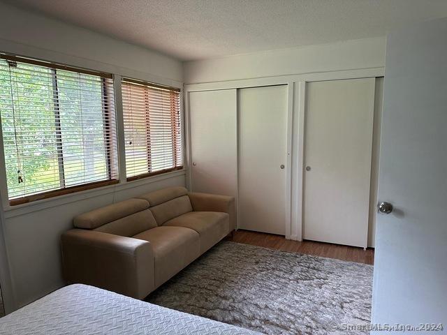 bedroom featuring multiple closets, dark wood-type flooring, and a textured ceiling