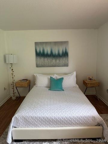 bedroom with dark wood-type flooring