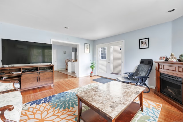 living room featuring french doors and light wood-type flooring