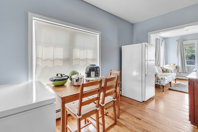 kitchen featuring light hardwood / wood-style floors, white refrigerator, and baseboard heating