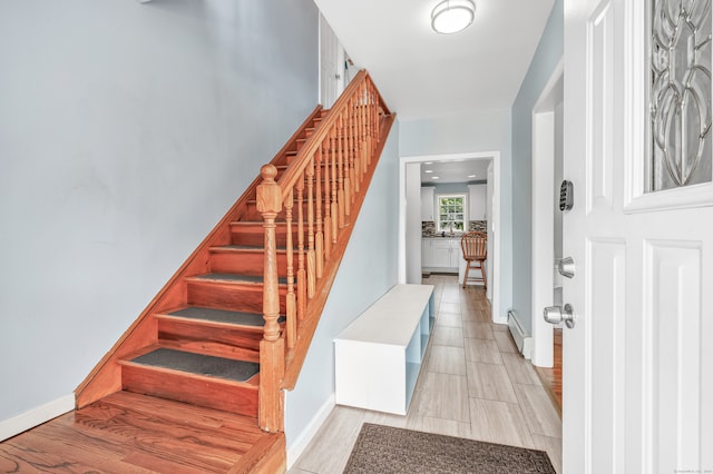 foyer entrance with light hardwood / wood-style flooring and baseboard heating