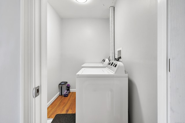 laundry room featuring separate washer and dryer and wood-type flooring