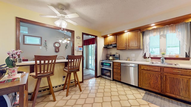 230 Unionville Ave, Plainville, CT 06062 - kitchen featuring appliances with stainless steel finishes, a sink, brown cabinetry, light countertops, and a ceiling fan
