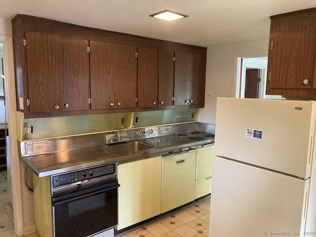 kitchen with sink, oven, and white refrigerator