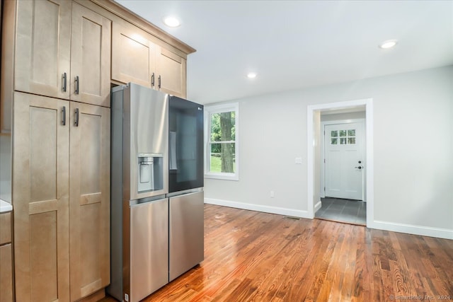 kitchen featuring stainless steel refrigerator with ice dispenser and hardwood / wood-style floors