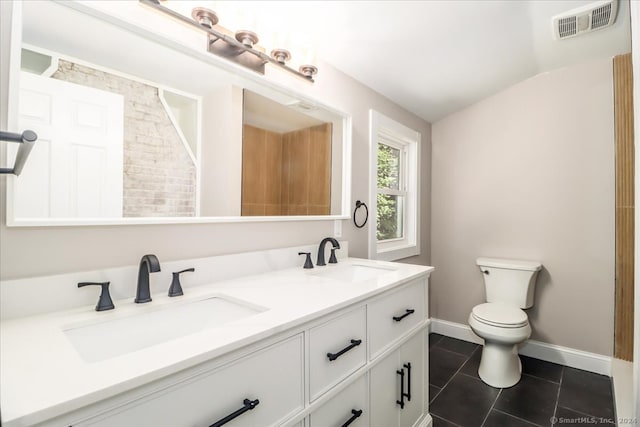 bathroom featuring toilet, dual bowl vanity, lofted ceiling, and tile patterned floors