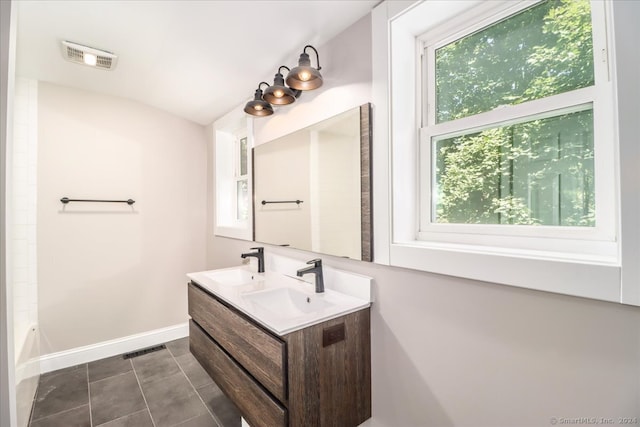 bathroom with washtub / shower combination, vanity, and tile patterned flooring